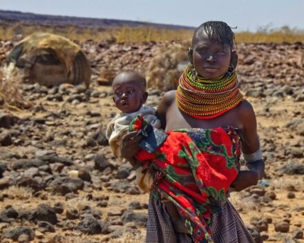 Asszony a gyerekével a Loiyangalaniba vezető út menti turkana faluban, Turkana-tó (KE) 2022. 03.